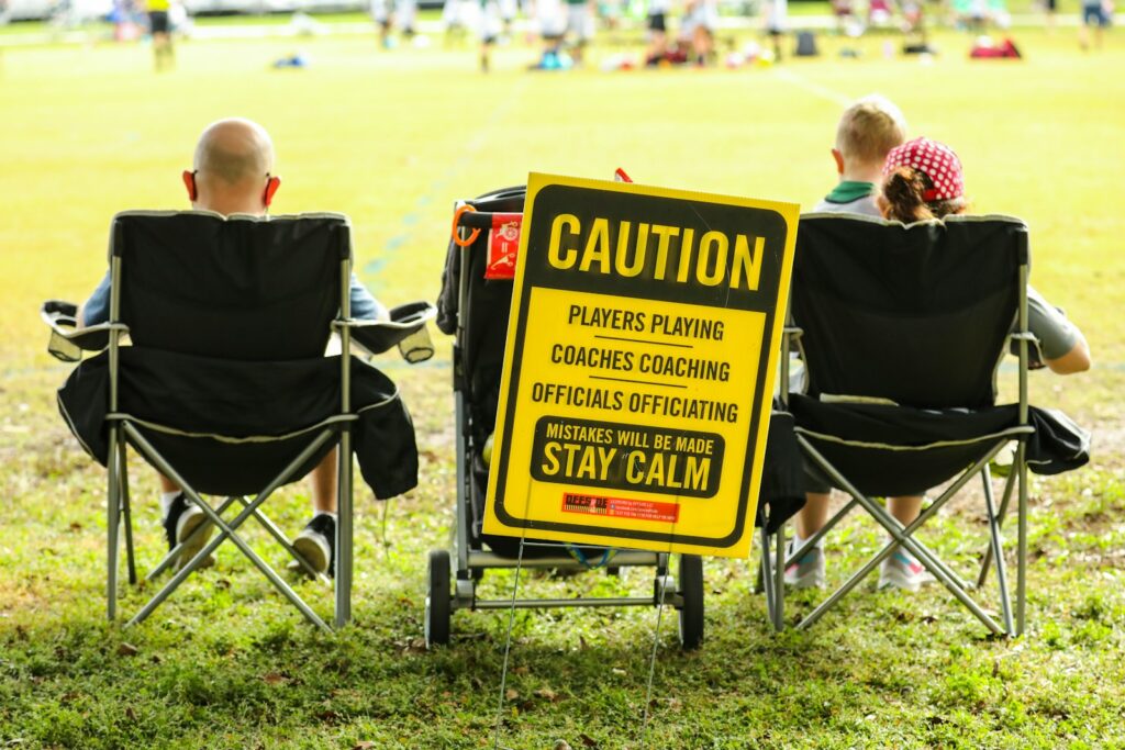 boy in black hoodie sitting on black and yellow folding chair